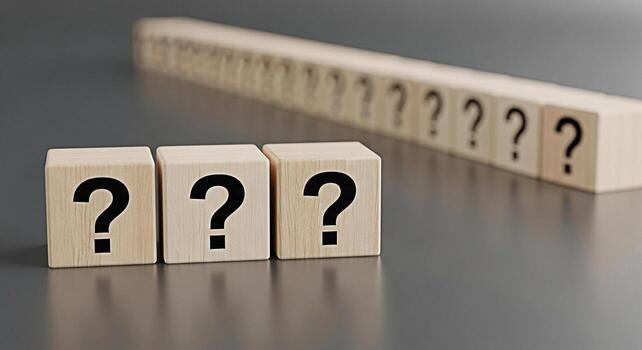 Wooden blocks displaying question marks on a gray surface symbolizing uncertainty and the search for answers in a conceptual and thoughtprovoking composition perfect for illustrating problemsolving photo