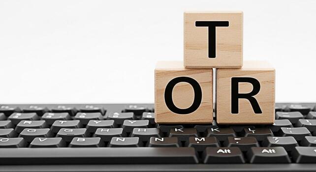 Wooden blocks spelling TOR resting on a black computer keyboard against a white background symbolizing technology online resources and the dark web in a modern digital age photo