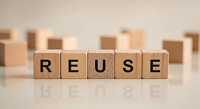 Wooden blocks spelling REUSE on a reflective surface promoting environmental awareness and sustainability conveying a message of conservation and responsible consumption in a minimalist setting photo