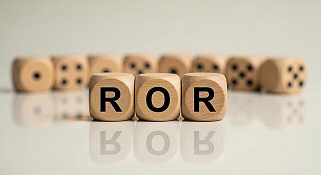 Wooden dice spelling ROR on a reflective surface representing the concept of Rate of Return in a financial setting conveying a sense of investment and economic analysis photo