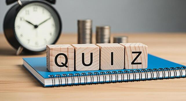 Wooden blocks spelling QUIZ sitting on a blue notebook with an alarm clock and stacks of coins in the background representing a test of knowledge and financial literacy in a timesensitive context photo