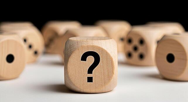 Wooden dice displaying a question mark on a white surface surrounded by other dice representing uncertainty and the need for decisionmaking in a complex and ambiguous situation photo