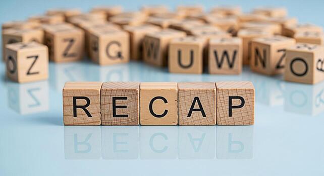 Wooden blocks spelling RECAP on a reflective surface with blurred alphabet blocks in the background symbolizing a summary review or overview of past events with a clean and modern aesthetic photo