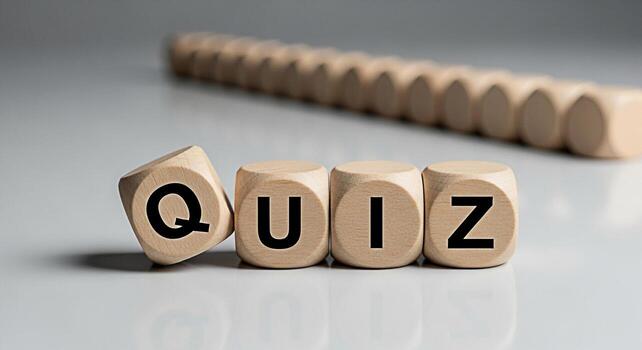 Wooden dice spelling QUIZ on a white surface with a row of blurred dice in the background representing a challenge knowledge assessment and the concept of testing ones understanding photo