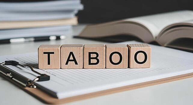 Wooden blocks spelling TABOO resting on a clipboard in a bright office environment representing controversial topics and sensitive issues creating a mood of caution and awareness in professional setti photo