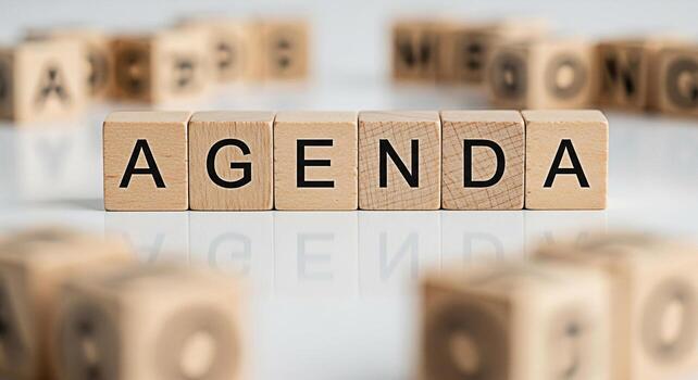 Wooden blocks spelling AGENDA on a reflective surface suggesting planning and organization in a business or meeting context conveying a sense of structure and preparation for a productive discussion photo