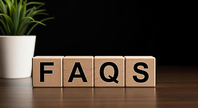 Wooden blocks spelling FAQs on a dark wooden table with a green plant in the background representing frequently asked questions and information creating a helpful and informative atmosphere photo