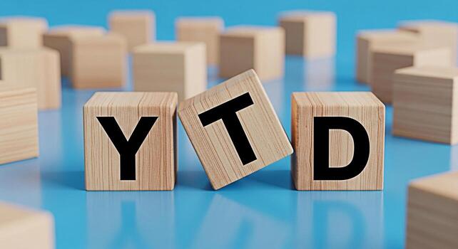 Wooden blocks displaying YTD on a blue surface representing Year To Date financial performance and progress tracking in a business setting conveying a sense of achievement and accountability photo