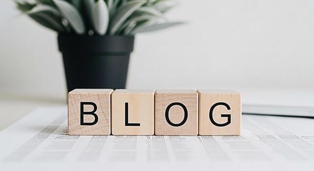 Wooden blocks spelling BLOG sit on a document in a bright minimalist office setting suggesting a focus on online content creation digital marketing and the importance of blogging for business growth photo