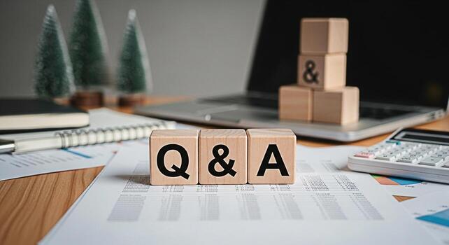 Wooden blocks displaying QA on a desk with financial reports a laptop and Christmas trees representing questions and answers for business strategy and planning in a festive office environment photo