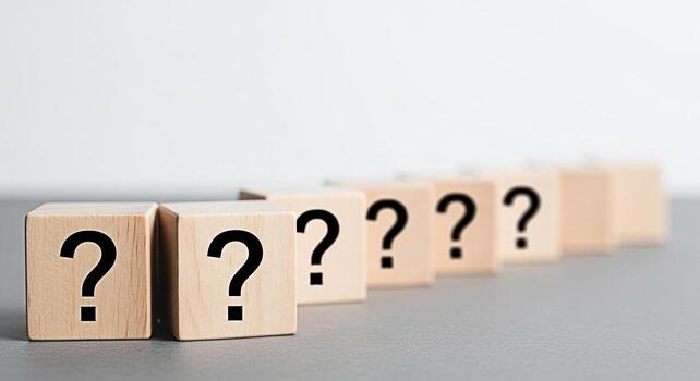 Wooden blocks displaying question marks on a gray surface symbolizing uncertainty and inquiry in a minimalist setting evoking curiosity and the search for answers in problemsolving scenarios photo