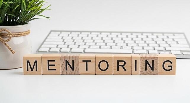 Wooden blocks spelling Mentoring on a white desk with a keyboard and a potted plant symbolizing guidance and support in a professional setting fostering growth and development with a clean modern aest photo