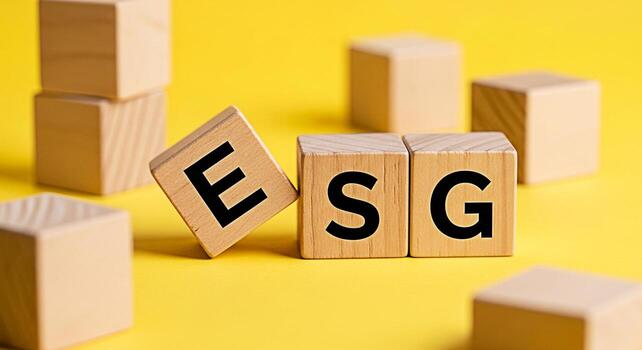 Wooden blocks displaying ESG letters on a bright yellow background representing environmental social and governance principles for sustainable and responsible business practices conveying a message of photo