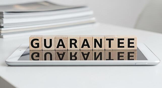 Wooden blocks spelling GUARANTEE resting on a tablet in a bright modern office symbolizing assurance and trust in business conveying a sense of reliability and customer satisfaction with a clean minim photo