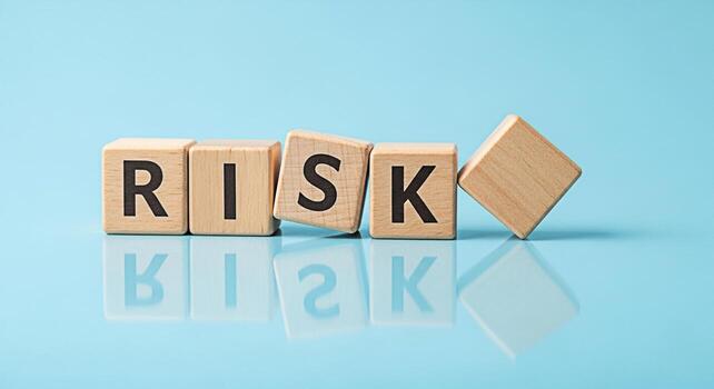 de madera bloques ortografía riesgo derribando en un reflexivo azul superficie simbolizando incertidumbre y potencial peligro en negocio y inversión decisiones creando un sentido de precariedad y desafío foto