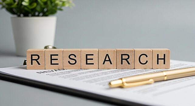 Wooden blocks spelling RESEARCH resting on a document with a pen in a bright office symbolizing investigation analysis and the pursuit of knowledge with a focus on accuracy and attention to detail photo