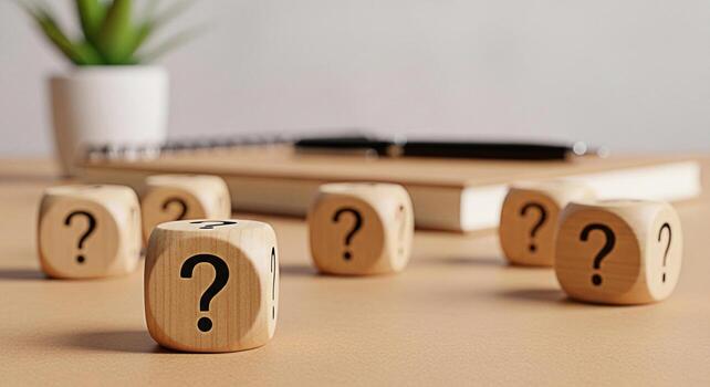 Wooden dice displaying question marks on a desk with a notebook and pen symbolizing uncertainty and the need for answers in a professional or educational setting fostering curiosity and problemsolving photo