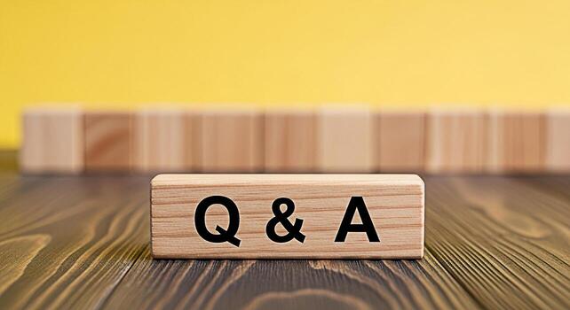 Wooden blocks displaying Q A on a wooden surface with a bright yellow background representing questions and answers knowledge sharing and the importance of information exchange in a clear and concise photo