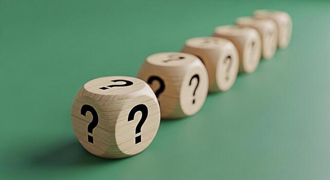 A row of wooden dice displaying question marks on a green surface symbolizing uncertainty and the need for answers creating a sense of curiosity and intrigue about the unknown challenges ahead photo