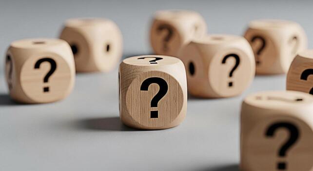 Wooden dice displaying question marks on a gray surface symbolizing uncertainty and the need for answers creating a mood of curiosity and problemsolving in a conceptual setting photo
