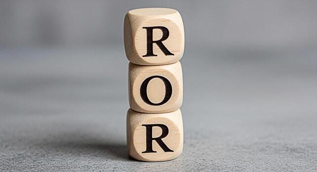 Stacked wooden blocks displaying ROR on a gray surface symbolizing return on risk investment strategy and financial analysis in a neutral and professional setting conveying precision and calculated de photo