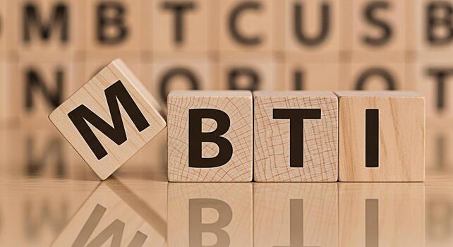Wooden blocks spelling out MBTI on a reflective surface representing personality assessment and psychological type creating a sense of clarity and selfdiscovery in a bright neutral setting photo