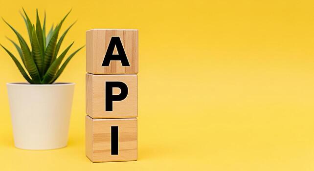 de madera bloques mostrando api siguiente a un en conserva planta en un amarillo antecedentes representando solicitud programación interfaz y moderno software desarrollo con un limpiar y minimalista estético foto