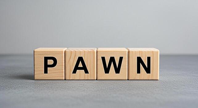 Wooden blocks spelling PAWN on a gray surface conveying a sense of strategy and risk in a minimalist setting ideal for illustrating business decisions and game theory concepts photo