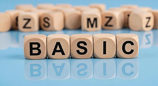 Wooden cubes spelling BASIC on a reflective blue surface surrounded by other lettered cubes representing fundamental concepts and simplicity in a clean minimalist setting conveying a sense of clarity photo