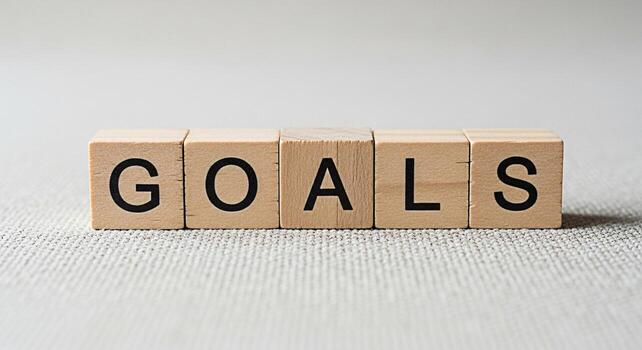 Wooden blocks spelling GOALS on a textured surface representing achievement and aspiration in a minimalist setting conveying a sense of focus and determination for success in personal and professional photo