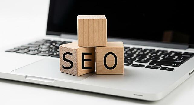 Wooden blocks spelling SEO resting on a modern laptop computer in a bright minimalist workspace symbolizing search engine optimization and digital marketing strategies for online business growth photo