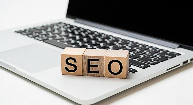 Wooden blocks spelling SEO resting on a laptop keyboard in a bright minimalist office setting representing search engine optimization and digital marketing strategies for online business success photo