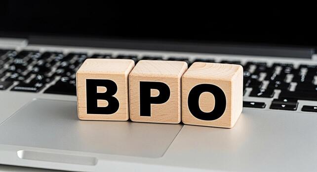 Wooden blocks spelling BPO sitting on a laptop keyboard in a modern office environment representing business process outsourcing and efficient workflow solutions for corporate success photo