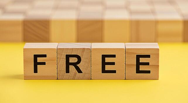 Wooden blocks spelling FREE on a bright yellow surface symbolizing opportunity and accessibility in a simple clean studio shot conveying a sense of openness and possibility for creative projects photo