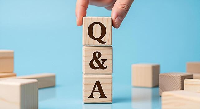 Hand stacking wooden blocks with Q A on a blue surface representing questions and answers knowledge and problemsolving in a simple and clear presentation ideal for educational or business concepts photo