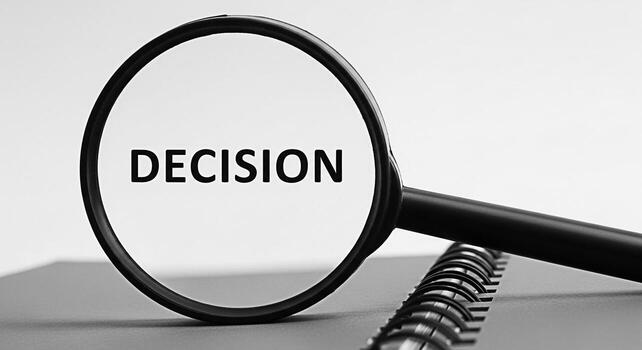 Magnifying glass focusing on the word Decision on a notebook symbolizing careful consideration and strategic planning in a neutral professional setting highlighting the importance of making informed c photo