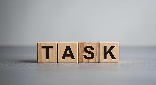 Wooden blocks spelling out TASK on a gray surface representing a challenge or assignment conveying a sense of focus and determination in a minimalist modern setting ideal for business and productivity photo