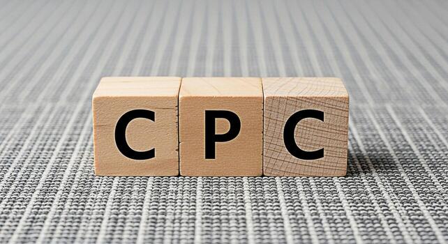 Wooden blocks displaying CPC on a textured gray surface representing cost per click advertising strategy conveying a message of online marketing and digital advertising success photo