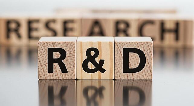 Wooden blocks displaying RD and Research on a reflective surface symbolizing innovation and development in a corporate setting fostering a mood of progress and strategic planning photo