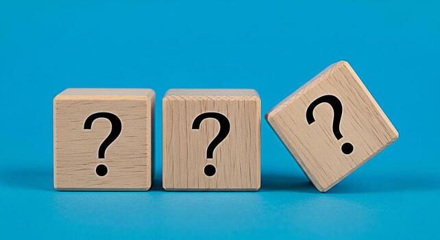 Three wooden blocks displaying question marks on a vibrant blue background symbolizing uncertainty and the need for answers creating a sense of curiosity and intrigue in a minimalist setting photo