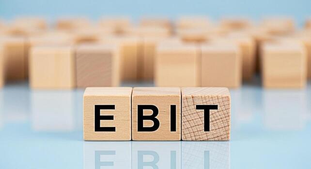 Wooden blocks displaying EBIT on a reflective surface representing earnings before interest and taxes in a financial setting conveying a message of financial performance and business analysis photo