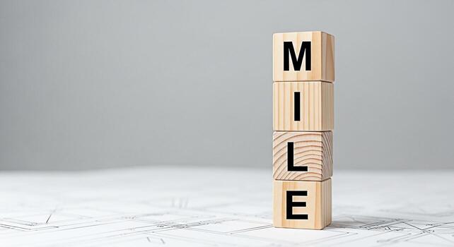 Stacked wooden blocks spelling MILE on a blueprint background symbolizing progress and achievement representing a significant milestone reached with precision and planning evoking a sense of accomplis photo