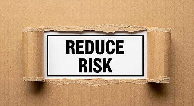 Torn cardboard revealing a message to Reduce Risk emphasizing the importance of risk management and mitigation strategies in a challenging business environment promoting safety and security photo