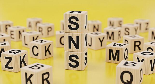 Wooden alphabet blocks spelling SNS on a yellow surface representing social media and networking conveying a message of connection and communication in a playful and educational setting photo