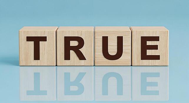 Wooden blocks spelling TRUE on a reflective surface against a light blue background representing honesty integrity and the importance of truth in communication and relationships conveying a sense of c photo