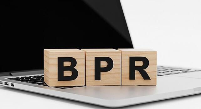 Wooden blocks spelling BPR resting on a laptop keyboard in a bright office setting symbolizing business process reengineering and the importance of digital transformation for improved efficiency photo
