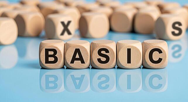 Wooden cubes spelling BASICS on a reflective blue surface representing fundamental concepts and essential knowledge conveying simplicity and a return to core principles in education and learning photo
