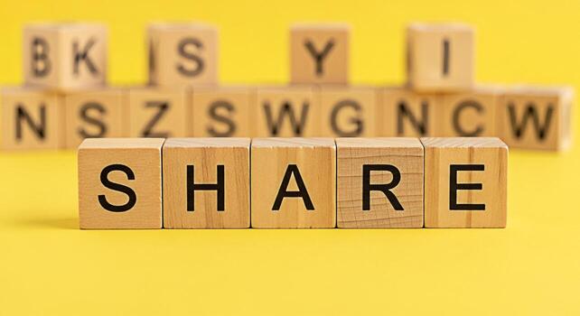 Wooden blocks spelling out SHARE on a vibrant yellow background promoting connection and community symbolizing the act of sharing information and resources in a collaborative and supportive environmen photo