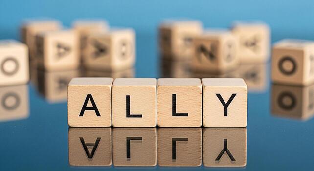 Wooden blocks spelling ALLY on a reflective blue surface symbolizing support and partnership in a collaborative environment fostering a sense of unity and understanding for diversity and inclusion ini photo