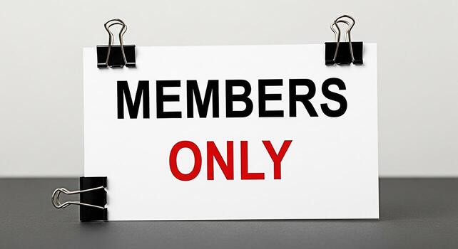 Closeup of a sign displaying Members Only in bold letters held by binder clips on a gray surface creating a sense of exclusivity and restriction in a professional setting photo